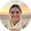 Staci Chialá, viaggiatrice luxury, sorridente con sciarpa di seta beige su sfondo desertico al tramonto